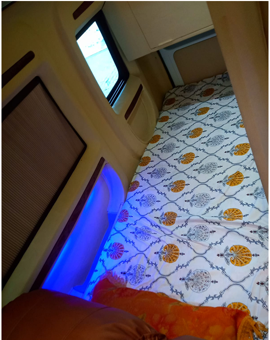 Van bed with patterned bedding and blue accent light